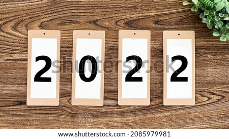 4 labels with 2022 characters on the wood board and green leaves background