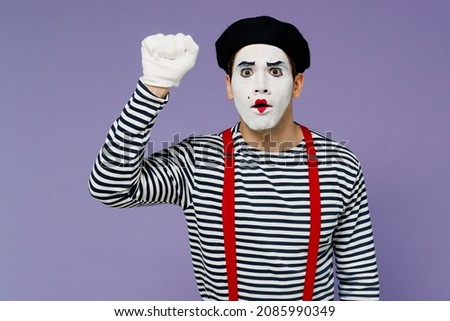 Surprised confused preoccupied perplexed puzzled young mime man with white face mask wears striped shirt beret making knocking gesture isolated on plain pastel light violet background studio portrait