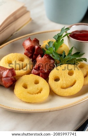 Funny face fries with roasted mini-sausages, a small and entertaining meal of a kids menu, appetizing photo