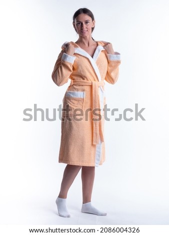 woman in a Bathrobe on an isolated white background with a smile on her face. Shot in the Studio in full growth.