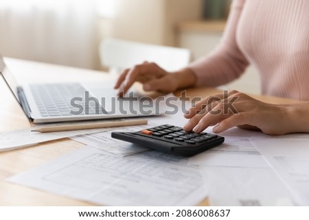 Close up cropped woman planning budget, using laptop and calculator, professional accountant calculating and paying domestic bills online, internet baking service, analyzing financial documents Royalty-Free Stock Photo #2086008637