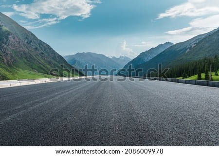 Straight asphalt road and mountain under blue sky. Highway and mountain background. Royalty-Free Stock Photo #2086009978