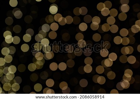 Bokeh lights in the black background. New Year concept. Christmas shiny decoration light. Yellow and prown and warm white boheh from lights on the black background.  Overlay for photograph, grafics