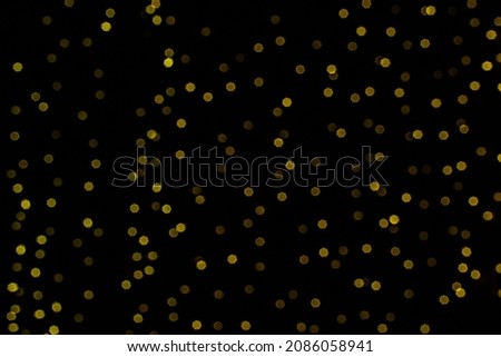 Bokeh lights in the black background. New Year concept. Christmas shiny decoration light. Yellow and prown and warm white boheh from lights on the black background.  Overlay for photograph, grafics