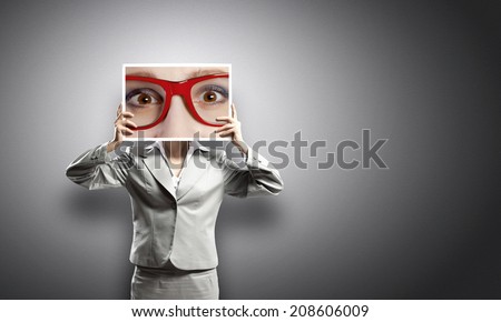 Businesswoman hiding face behind photo of eyes