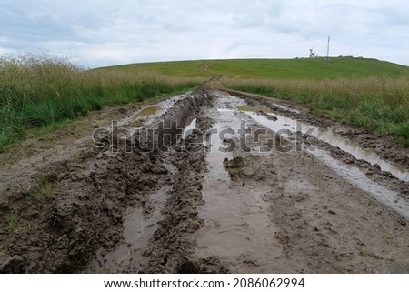 Puddles after rain on dirt road in mountains Royalty-Free Stock Photo #2086062994