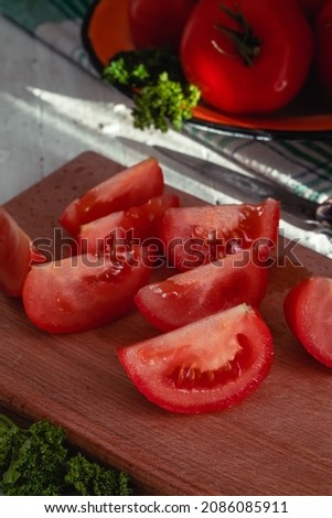Slices of red tomato on a wooden board. Sliced tomato to make tomato juice.