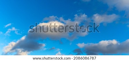 Fluffy clouds against blue sky. Space for text. Nature concepts. Many cumulus white clouds in blue sky. Image for design.