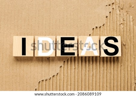 ideas. text on five wooden blocks. cubes on torn paper