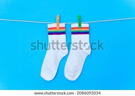 pair of rainbow-colored socks in blue background isolate .
