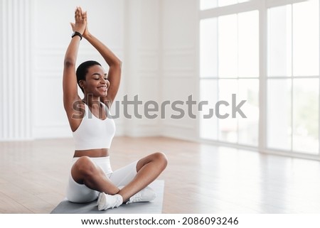 Indoor Yoga Practice. Young African American woman practicing Padmasana Lotus Pose seated asana with hands raised up in namaste mudra at home. Healthy Lifestyle Concept. Free copy space Royalty-Free Stock Photo #2086093246