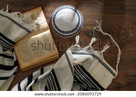 Jewish traditional prayer supplies. Talite, kippah, torah on a wooden table. Shabbatt, Bar Mitzvah, Yom kippur concept Royalty-Free Stock Photo #2086093729