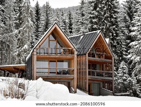 cabin in the woods. the soroundings are covered in snow. The cabin is made out of wood. the contrast is not to high. The picture is perfect to show a relaxing place in the woods.