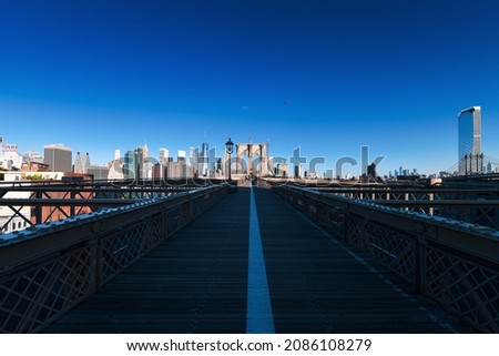 Impressive wide view from Brooklyn Bridge to the entire Manhattan in New York. One of the most visited places in America. Empty and with few people during COVID-19 pandemic. Difficult to travel.