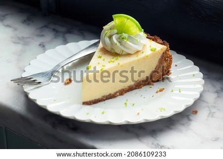 Slice of Key Lime Pie with Whipped Cream and Lime Zest on a Plate Royalty-Free Stock Photo #2086109233