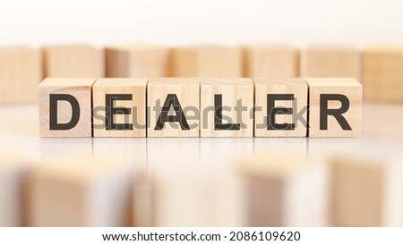DEALER word written on wooden cubes standing in a row. around the blocks with letters on a light background. can be used for business and financial concepts. selective focus