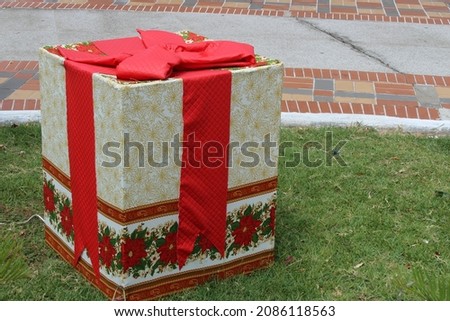 Christmas gift box with red bow as decoration for festivities in square.