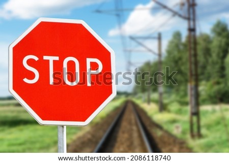 Stop sign background. Long railway landscape. Road sign suggesting caution. Watch out for a train. Rail road crossing. Attention danger background.