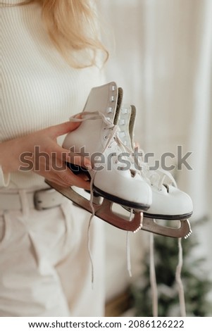 White skates in female hands . New year photo