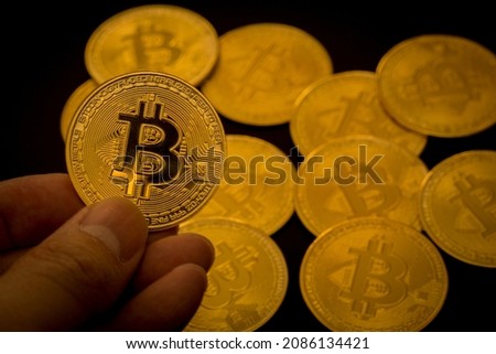 Close up shot of Bitcoins coins at fingertip. Crypto currency, bitcoin, BTC, Blockchain technology, bitcoin mining.