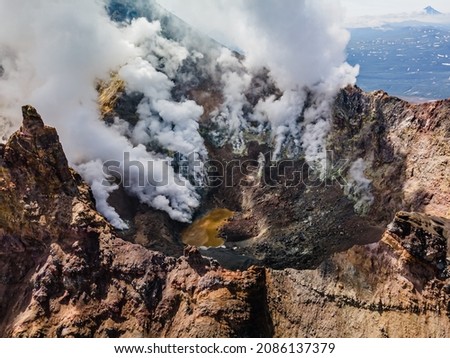 An airborne view on a smoking crater of Mutnovsky volcano in Kamchatka, Russia. Royalty-Free Stock Photo #2086137379