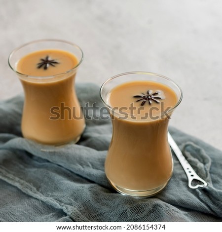 Masala chai. Hot tea with milk and spices on a light background.