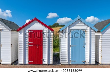 Colourful beach houses. Row of multicolored beach huts against blue sky. Royalty-Free Stock Photo #2086183099