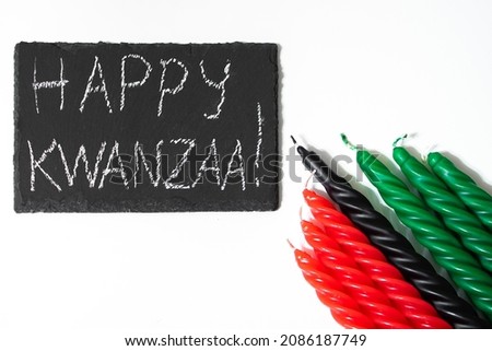 Happy Kwanzaa concept. African American holiday. Congratulatory lettering and seven candles - red, black and green. African heritage symbol on a white background.