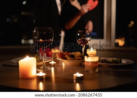 romantic dinner setting, red wine in glasses and candles, date for two, Valentine's Day evening, burning candles on the table, close-up Royalty-Free Stock Photo #2086267435