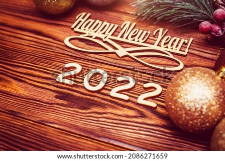Happy new year 2022 on wooden brown background 