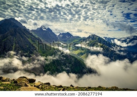  Landscape with clouds. Panoramic view of Kashmir valley in the Himalayan region. Serene meadows, alpine trees, wildflowers on the trails Kashmir Great Lakes Trek, Sep. 2021 India. Royalty-Free Stock Photo #2086277194