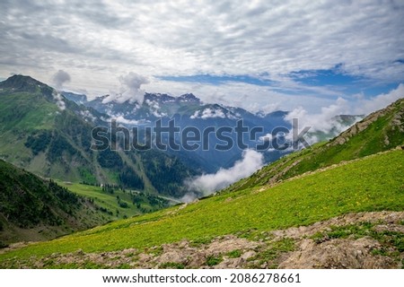 Landscape with mountains and clouds. Panoramic view of Kashmir valley in the Himalayan region. Serene meadows alpine trees, wildflowers on the trails Kashmir Great Lakes Trek, Sep .2021 India . Royalty-Free Stock Photo #2086278661
