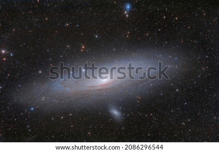 Photo of a galaxy in the constellation Andromeda, taken with an amateur telescope. Photos of real space objects. A large number of small stars throughout the image field. Soft focus.