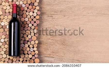 red wine bottle on wine corks background top view
