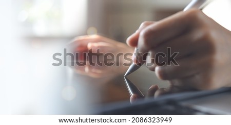 Close up, business woman hand using stylus pen working on digital tablet, signing digital release on table. creative designer hand working on tablet via mobile app, paperless office, E-signing concept