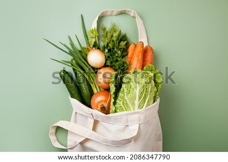 Eco bag with Fresh vegetables. Eco-friendly shopping. Fabric shopper on green background. Vegan Concept. Zero waste. Organic herbs. Plastic-free concept. Reusable mesh. Sustainable lifestyle Royalty-Free Stock Photo #2086347790