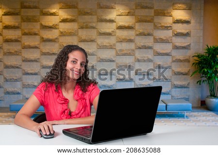 Beautiful computer savvy young woman using a laptop 