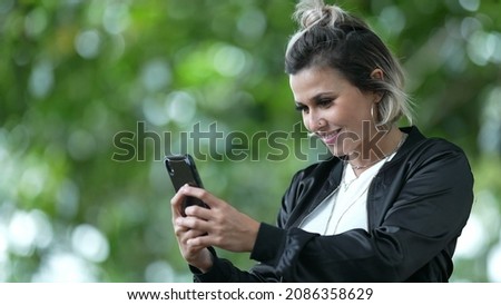 Girl taking picture with cellphone. person takes selfie outside.