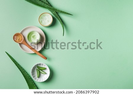 Aloe vera plant leaves and gel for skin care  on green, top view, copy space. Natural organic aloe vera cosmetics for face and body care. Royalty-Free Stock Photo #2086397902