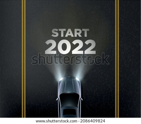 new year 2022 concept with car headlights, 2022 painted on road  Royalty-Free Stock Photo #2086409824