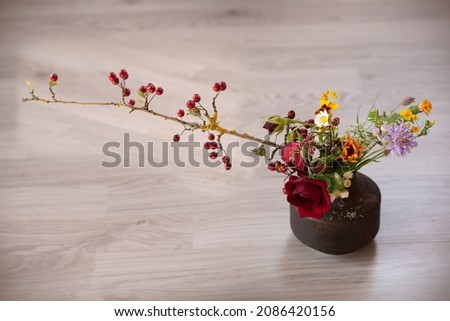 Autumn bouquet from seasonal flowers and wild berries branch