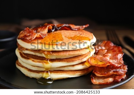 Delicious pancakes with maple syrup and fried bacon on plate, closeup Royalty-Free Stock Photo #2086425133