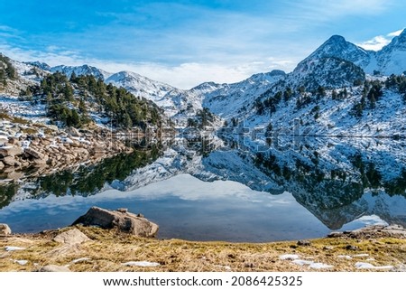 Reflection of the snowy mountains in the beautiful Baciver lake in the Pyrenees mountains of Val d'Aran (Aran Valley), Lleida, Catalonia, Spain Royalty-Free Stock Photo #2086425325