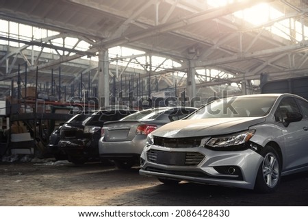 Many unknown altered wrecked car after traffic accident crash at restore service maintenance station garage indoor. Insurance salvage vehicle auction wholesale. Auto body wreck damage workshop center Royalty-Free Stock Photo #2086428430