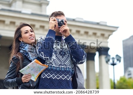 Happy love couple of tourists taking photo on excursion or city tour. Traveling together