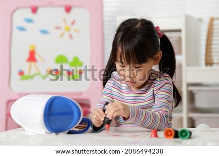 young girl making 3D shape craft for homeschooling