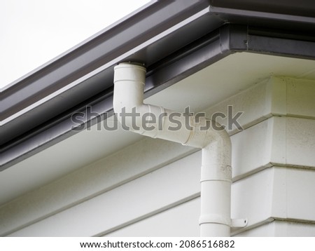 View of metal gutter and plastic downspout of typical New Zealand weatherboard house