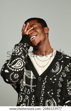 Vertical waist up portrait of anonymous African American man wearing cardigan and laughing Royalty-Free Stock Photo #2086523977