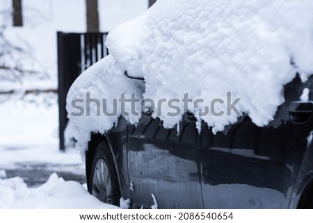 Car under layers of snow in the front yard of house, winter time concept  