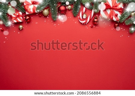 Red Christmas background with fir ornaments and holiday gifts. Flat lay, top view and copy space for text